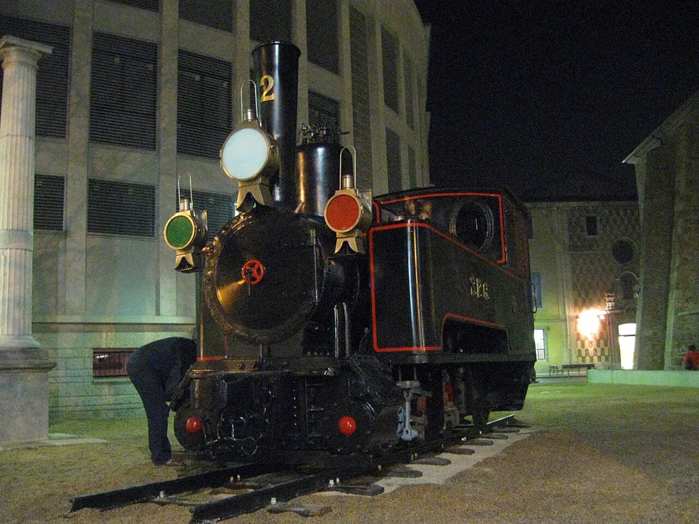A steam locomotive under night lighting, handheld at ISO 800.