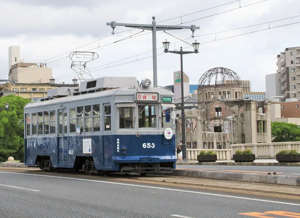 A tram by a park, photographed with a Canon PowerShot ELPH 360 HS. We found no free-licence photo of the camera itself.
