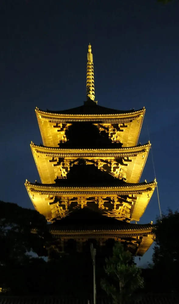 A temple pagoda lit at night, handheld.