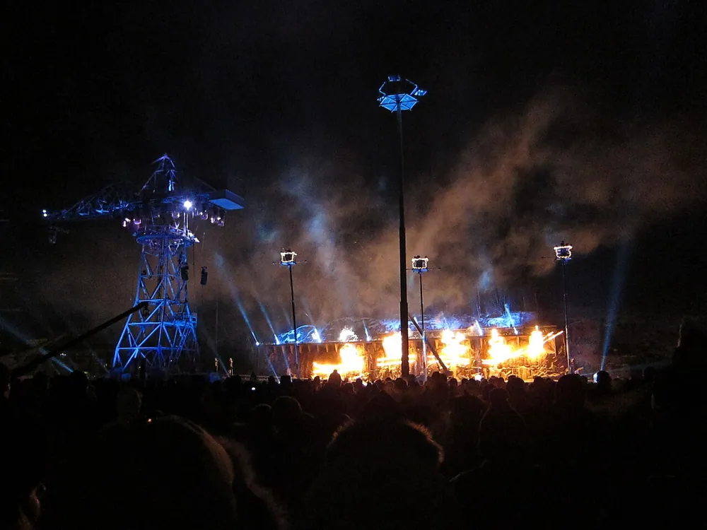 Fire, smoke and floodlights at night, handheld at ISO 2500.