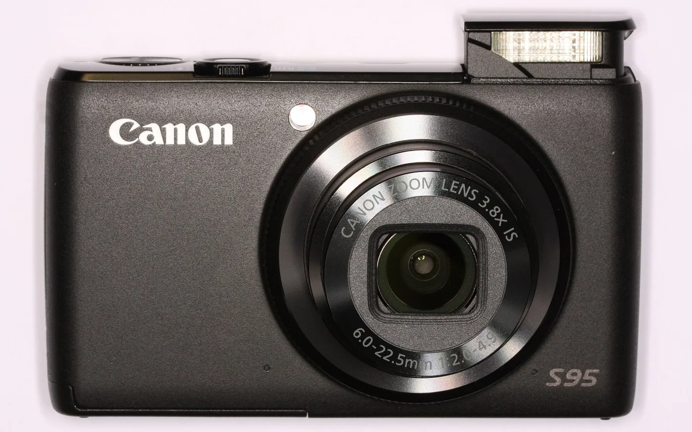 The Canon PowerShot S95 with its flash raised.