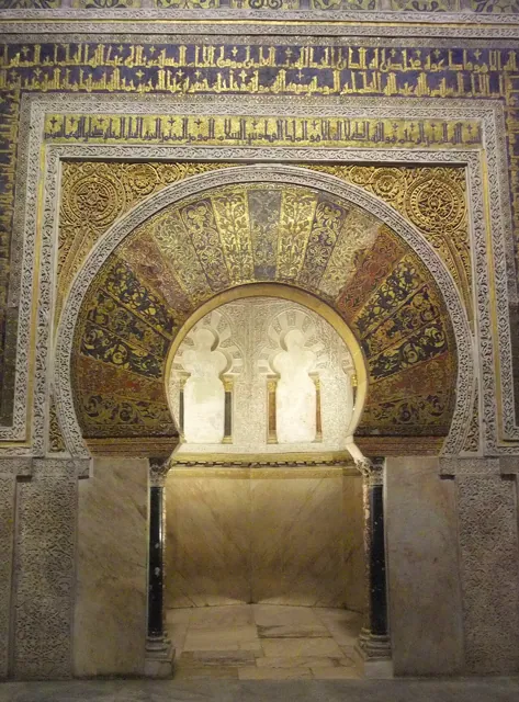 A mosque interior with a gilded arch