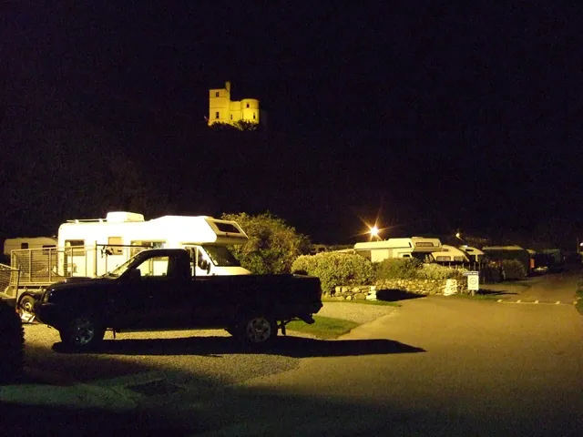 A campsite and its floodlit tower at night, at the camera's top sensitivity.