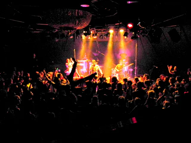 A band on a small stage, seen from the crowd