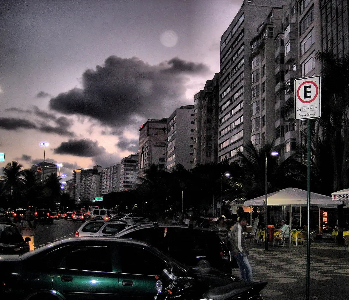 A city seafront after dusk, lit by street lamps