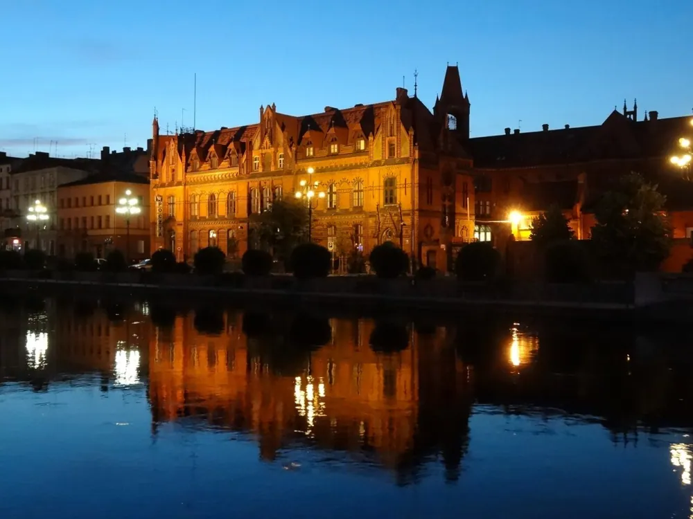 A riverside at blue hour with reflections, handheld.