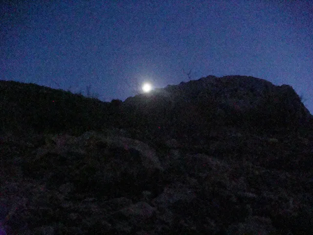 The moon over a cliff at night
