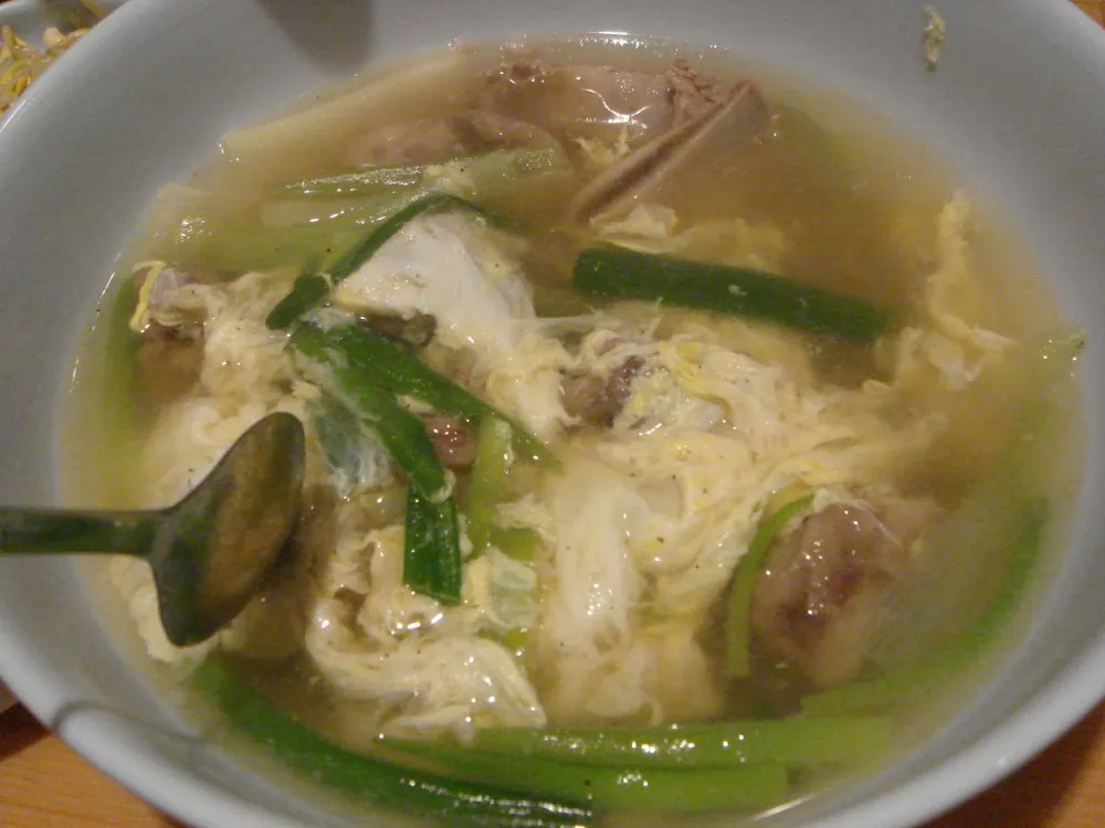 A bowl of soup on a restaurant table, at ISO 640.